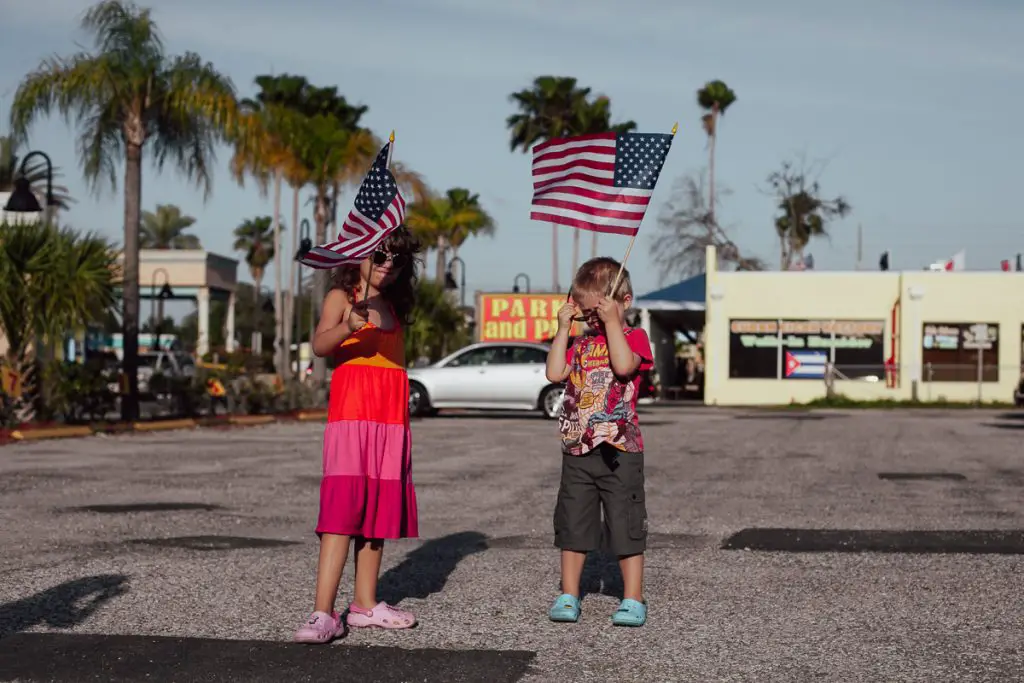 Kids waving US flags in Tarpon Springs