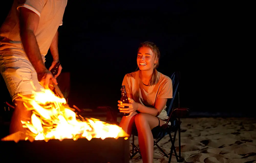 Young couple enjoying the night with a bonfire at Miami Beach